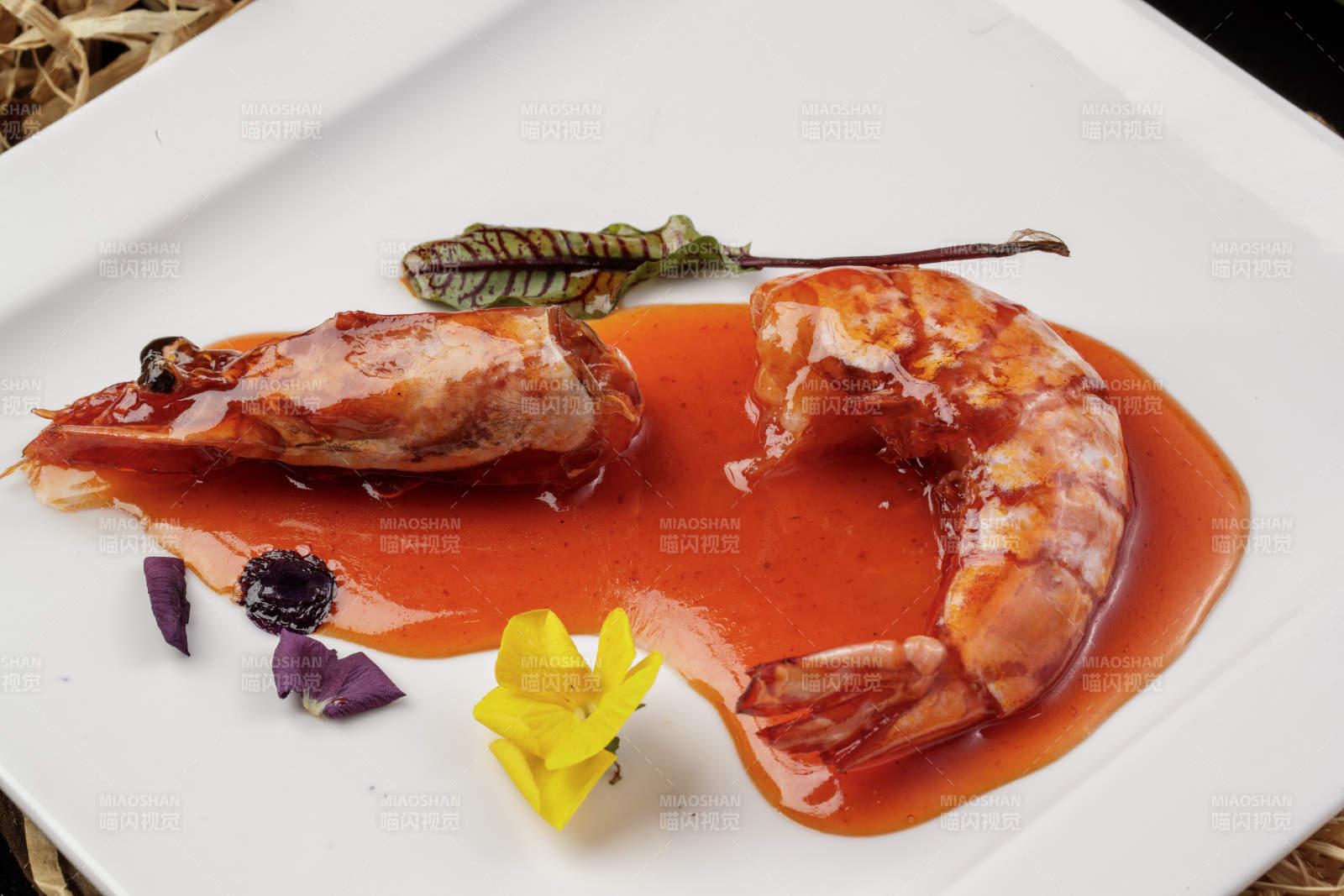 方形瓷盤裝的澆汁大明蝦擺放在樟木砧板上