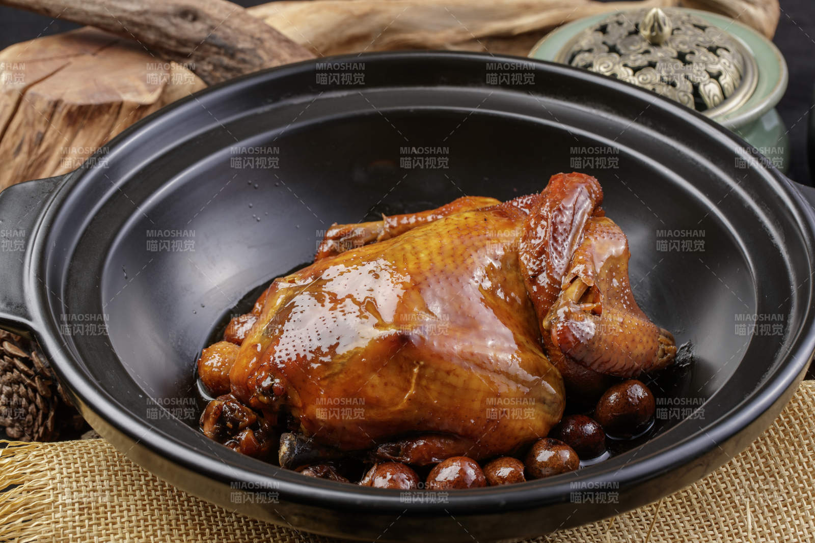 黑色砂锅装的板栗鸡摆放在麻布垫子上