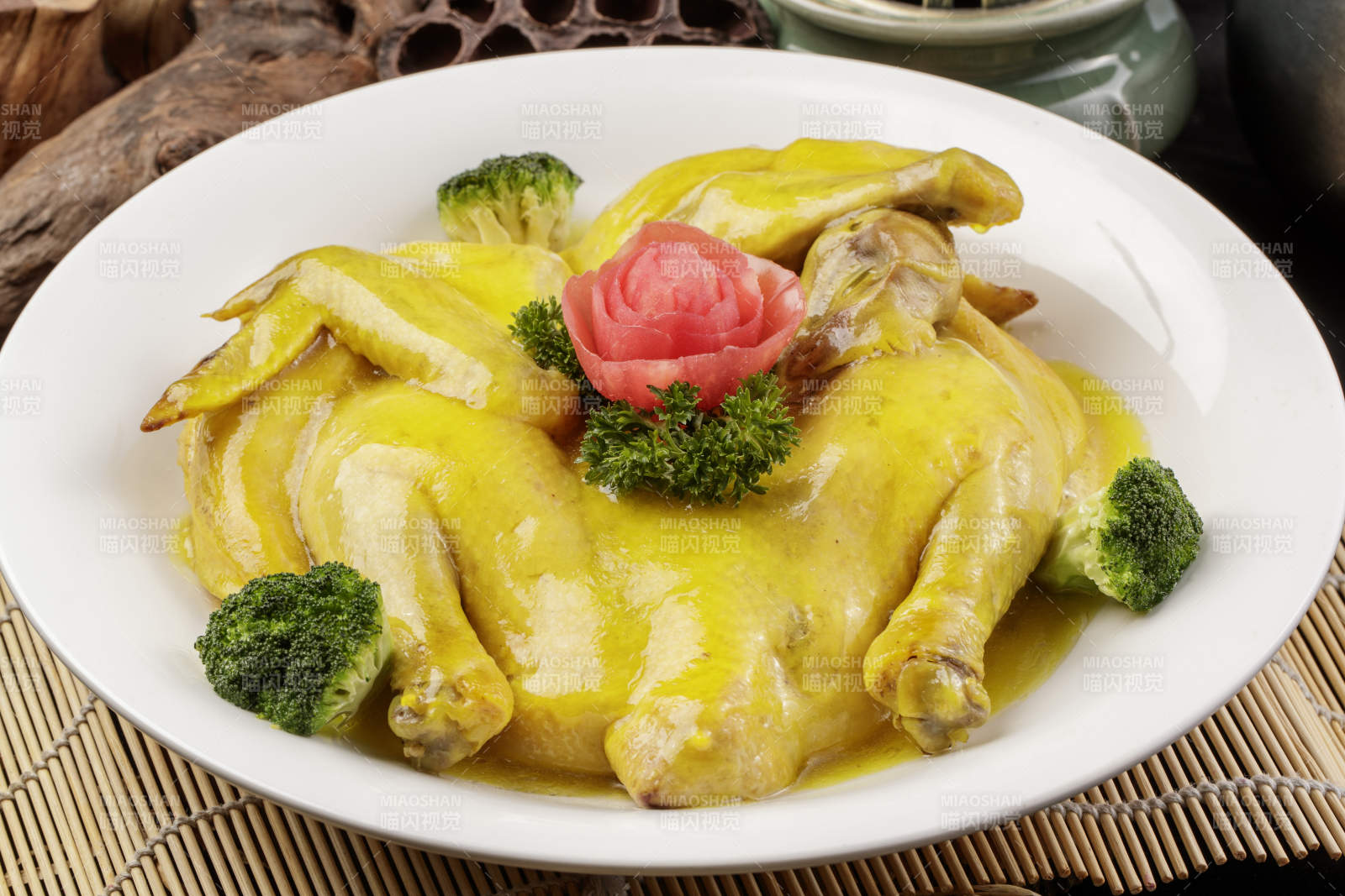 圆形瓷盘装的清蒸三黄鸡摆放在寿司帘上