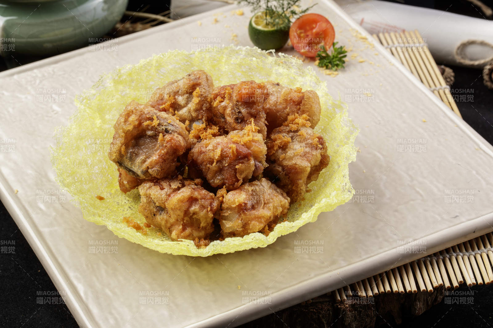 米色放瓷盘装的金盏猪小排摆放在寿司帘上