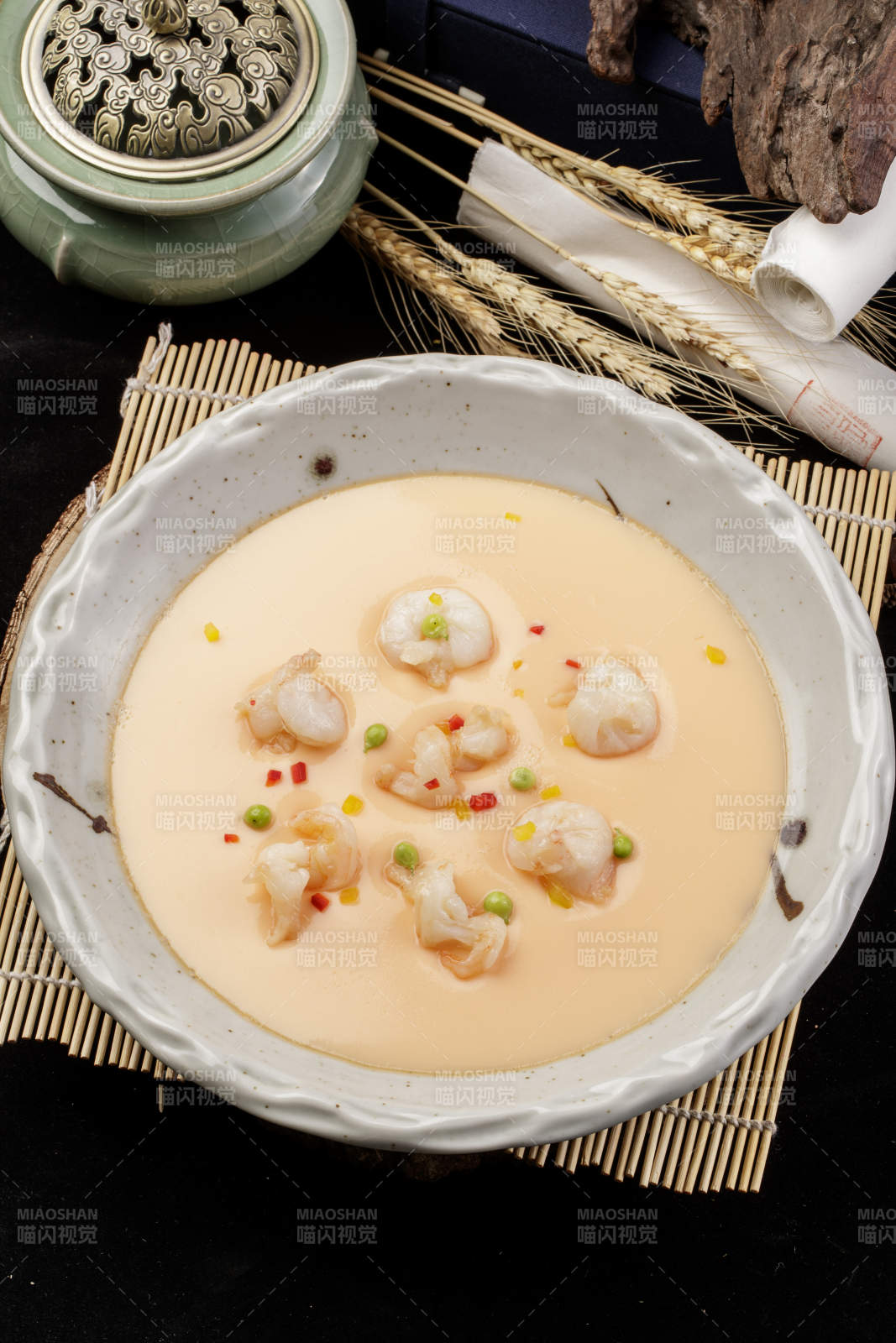 米色圓盤裝的蝦仁蒸水蛋擺放在壽司簾上