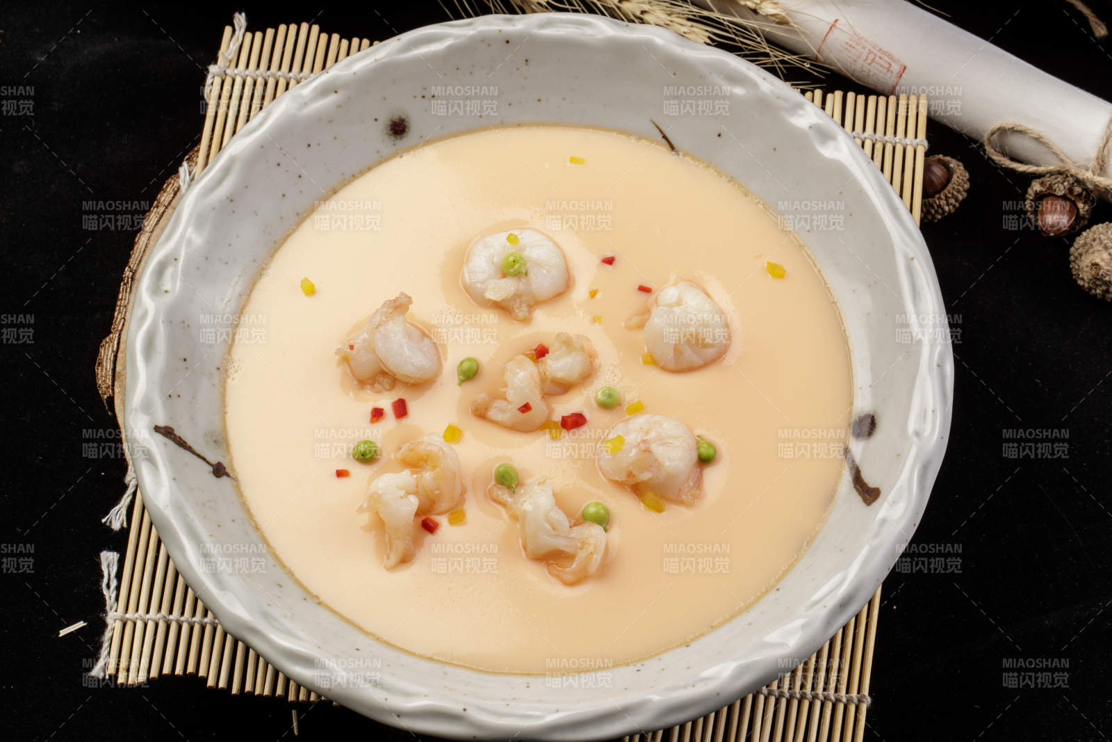 米色圓盤裝的蝦仁蒸水蛋擺放在壽司簾上