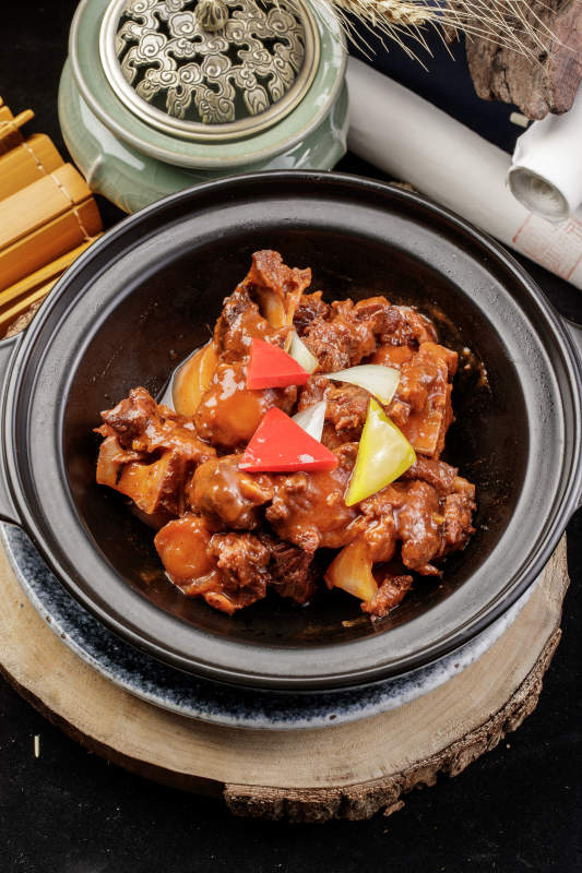 黑色砂锅装的黄焖牛尾