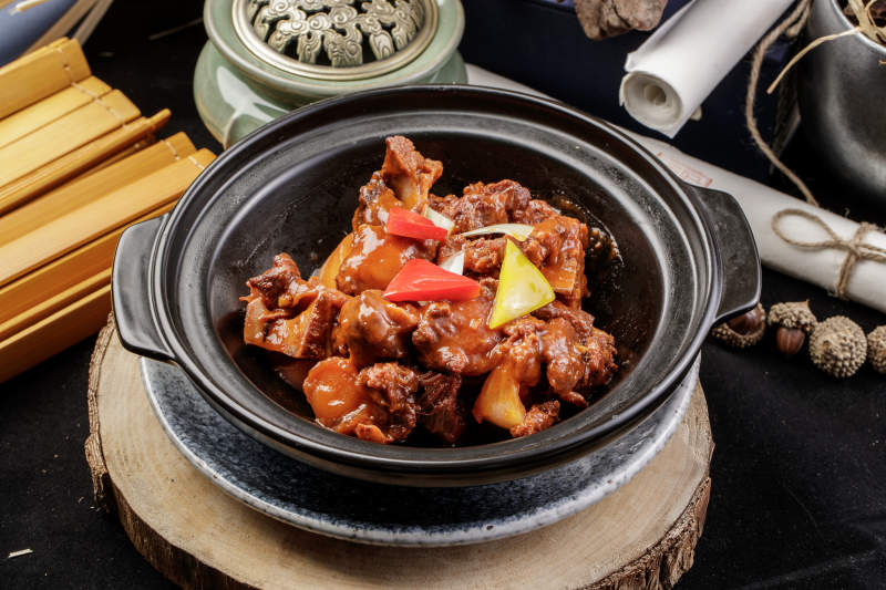 黑色砂锅装的黄焖牛尾