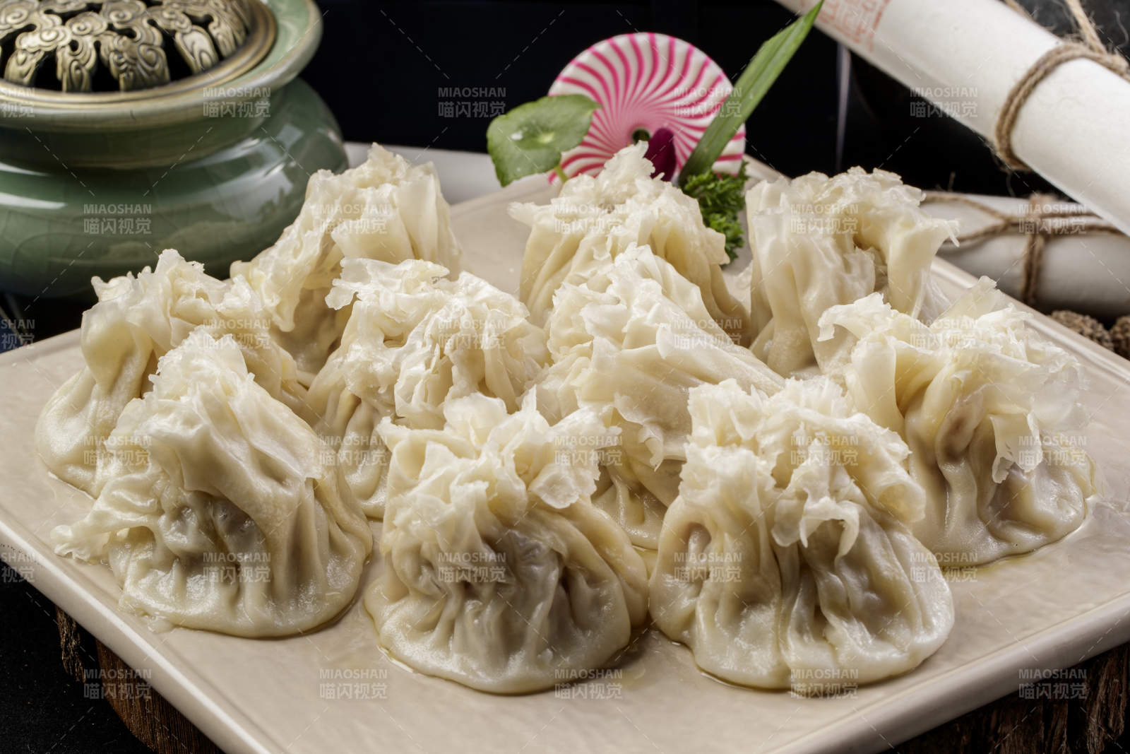 米色瓷盘装的美味烧麦摆放在黑色背景上