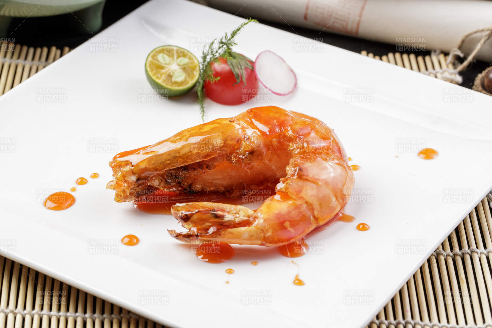 方形瓷盘装的油煎浇汁深海虾摆放在寿司帘上
