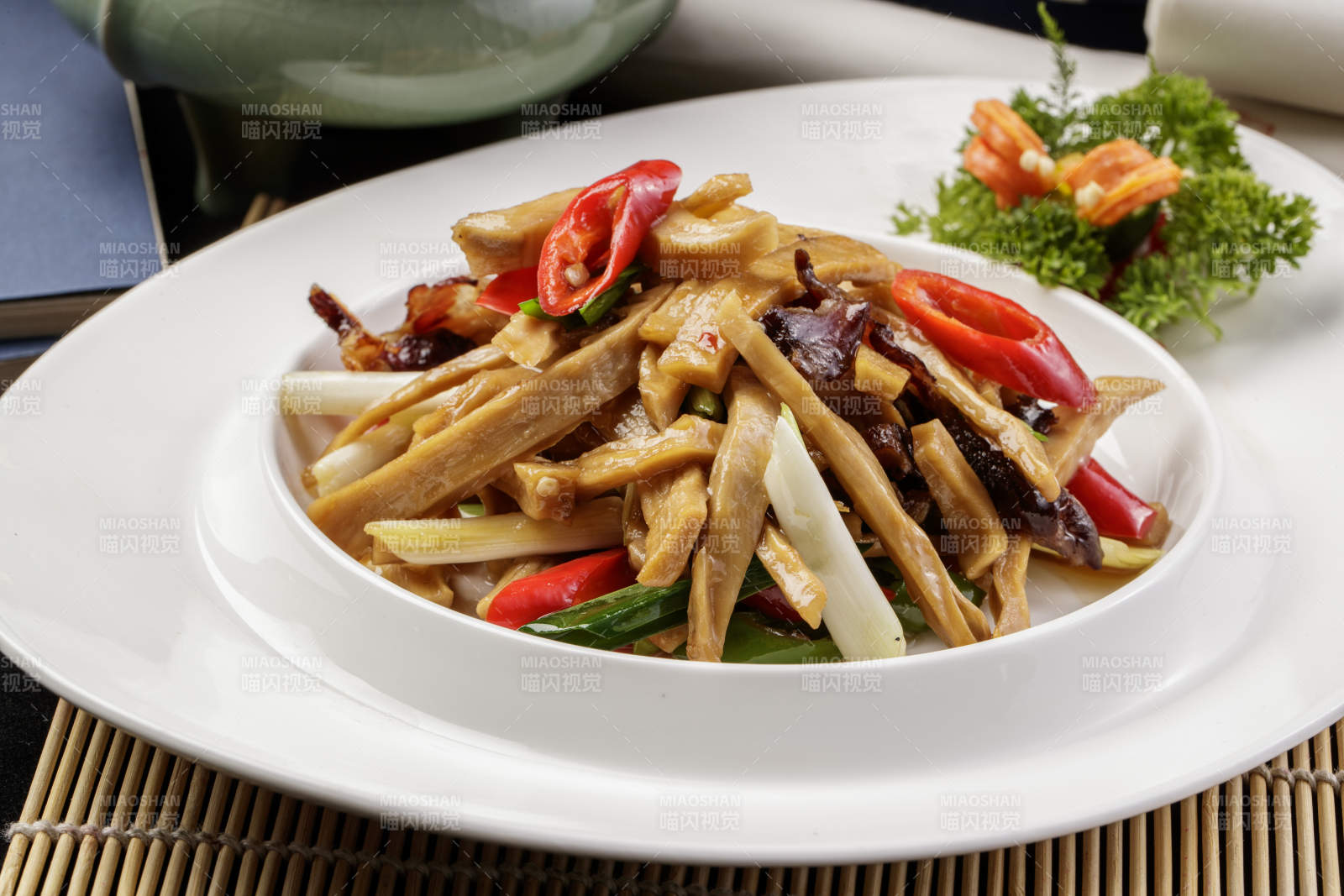 白色瓷盘装的的大葱烧猪肚