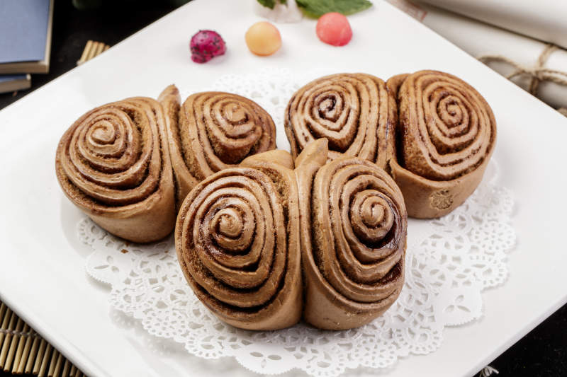 白色瓷盘装的黑豆面肉龙卷