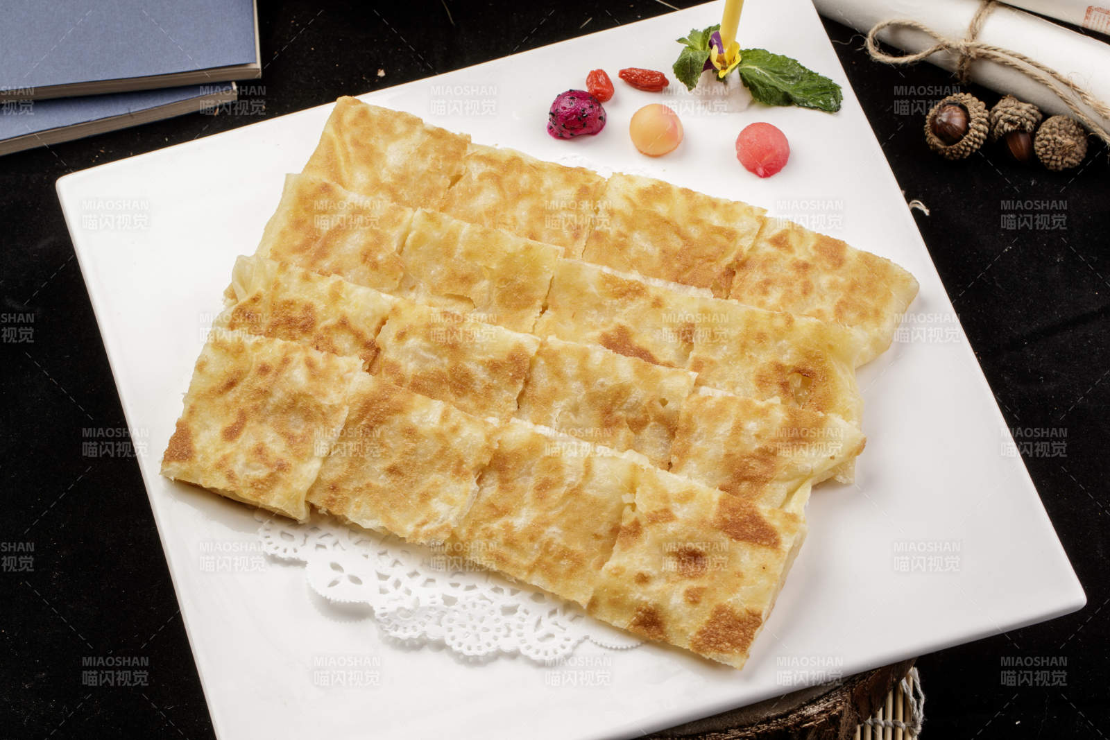 方形瓷盤裝的印度飛餅擺放在樟木砧板上