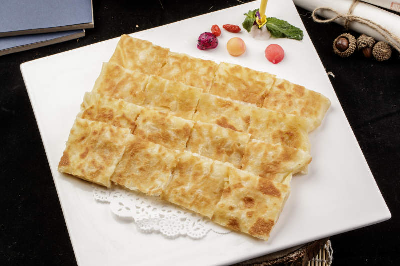 方形瓷盤裝的印度飛餅擺放在樟木砧板上