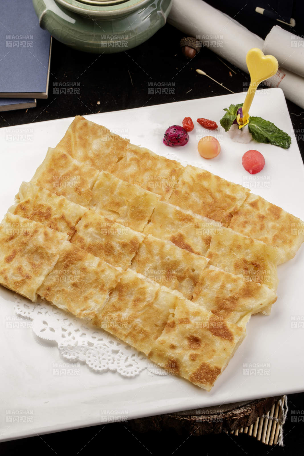 方形瓷盤裝的印度飛餅擺放在樟木砧板上