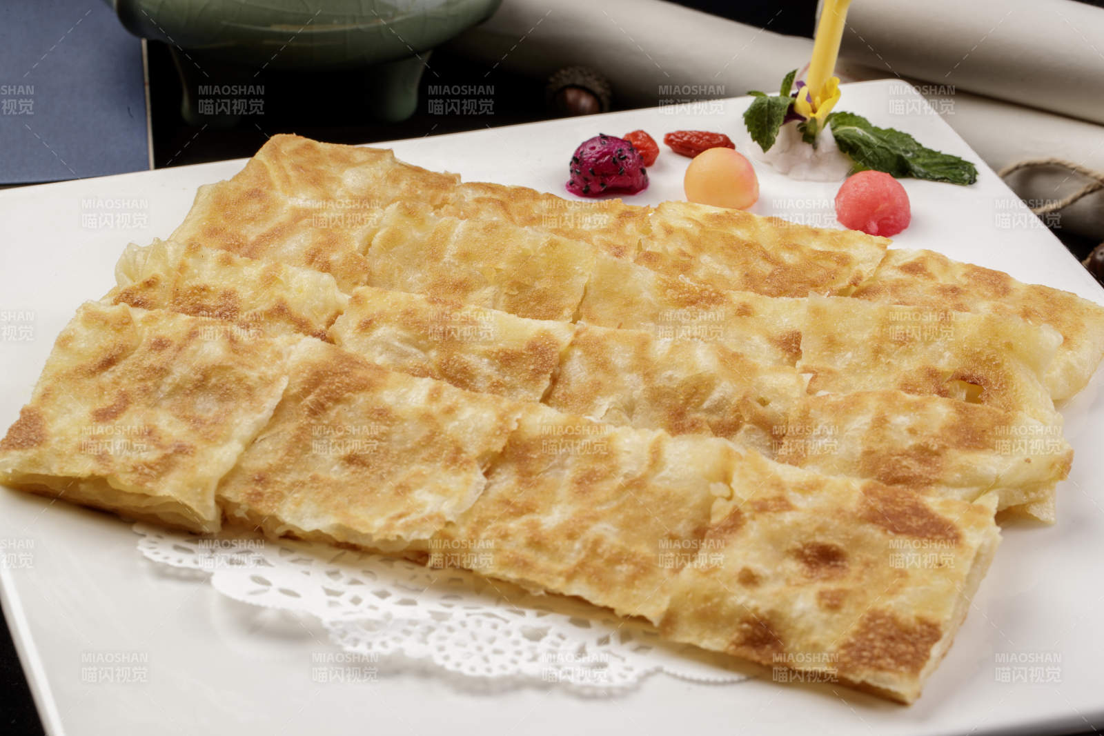 方形瓷盤裝的印度飛餅擺放在樟木砧板上