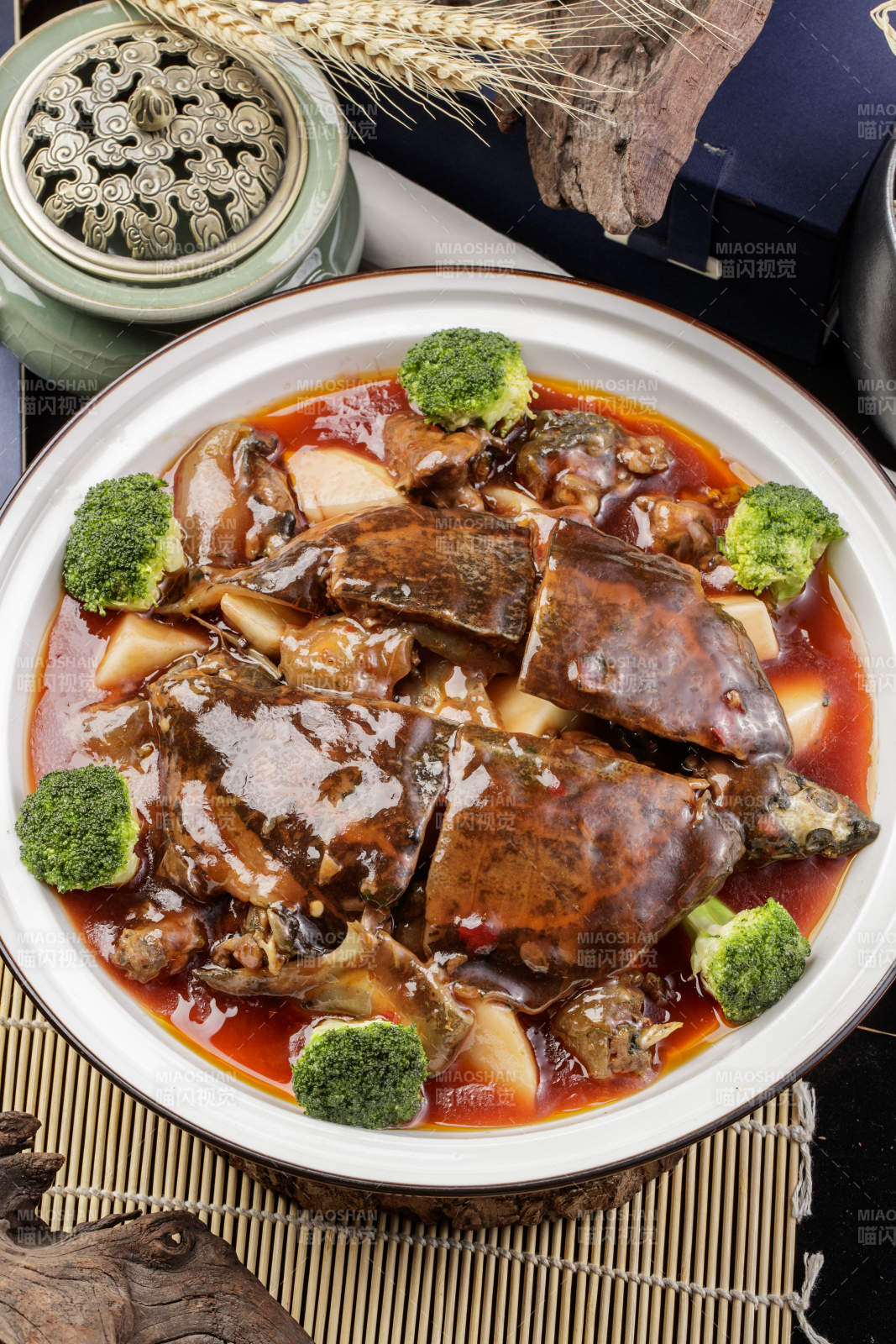 白瓷大圆盘装的浓汤炖甲鱼摆放在寿司帘上
