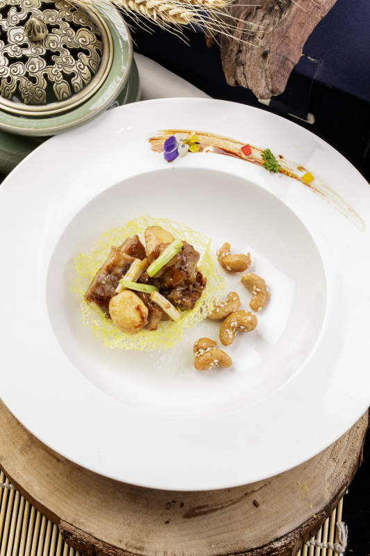 蒜香金盏牛仔粒摆放在樟木砧板上-摄影图