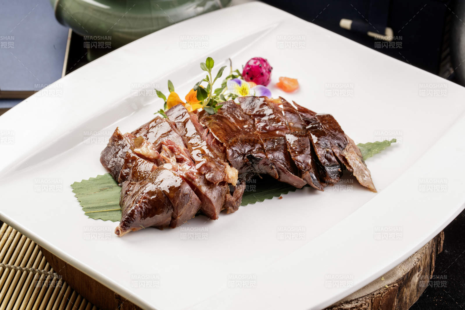 白瓷盘装的苏州酱鸭摆放在寿司帘上