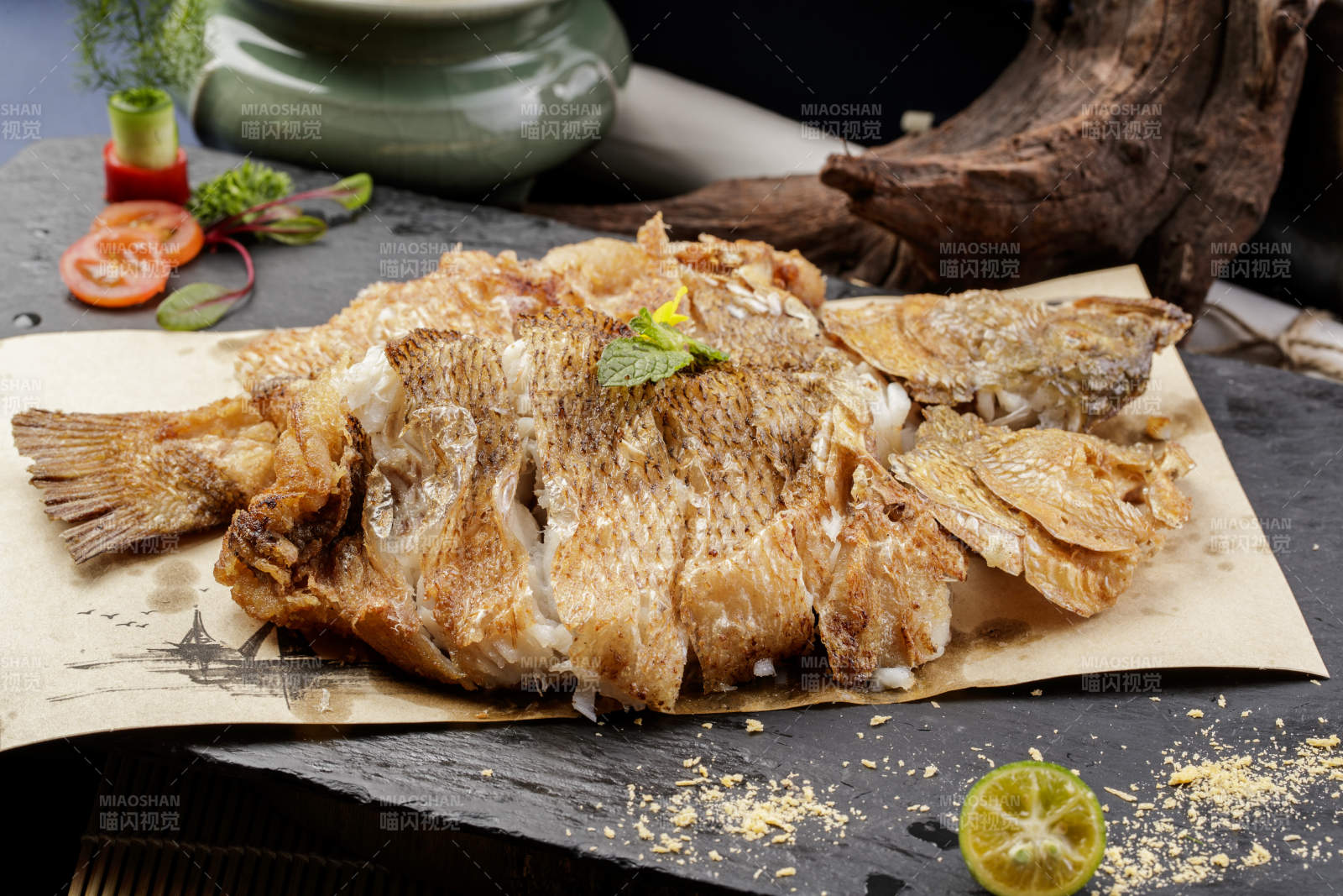 香酥炸高背鯽魚擺放在黑色背景上