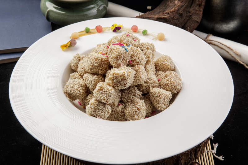 圆形瓷盘装的麻仁红薯摆放在寿司帘上