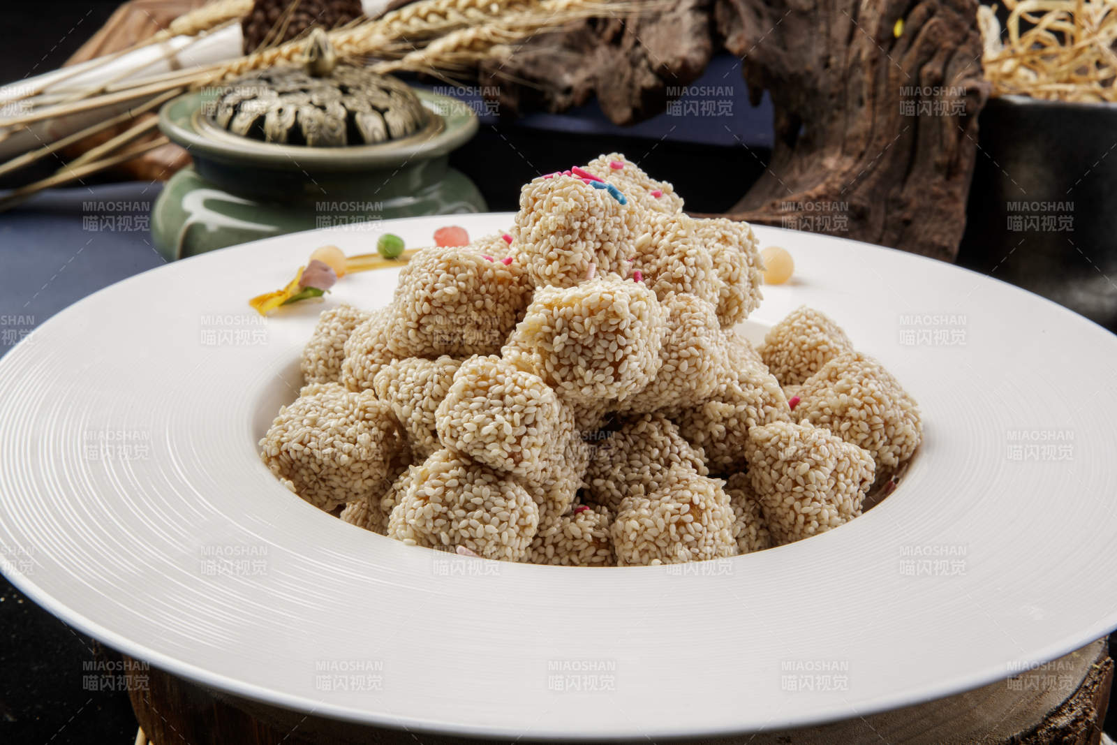 圆形瓷盘装的麻仁红薯摆放在寿司帘上