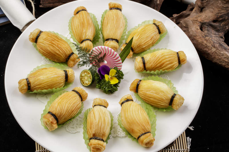 制作精美的泰国榴莲酥摆放在米黄色磁盘上