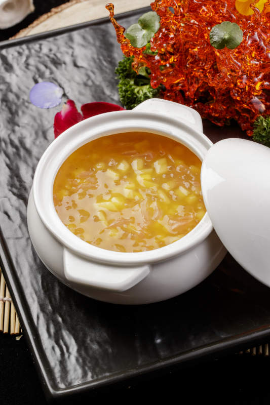 白色汤盅装的木瓜银耳羹摆放在黑色石盘上