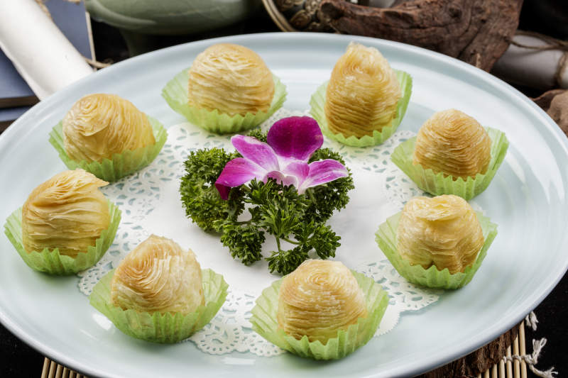 青瓷盘装的木瓜酥摆放在寿司帘上