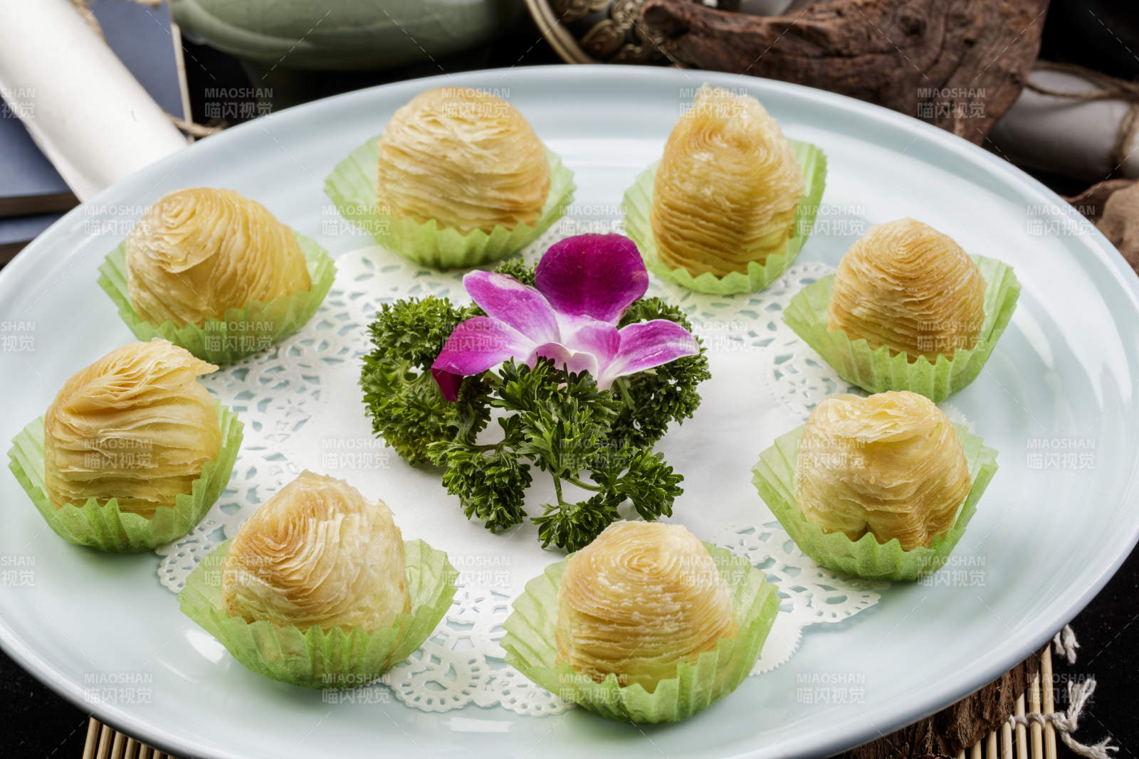 青瓷盘装的木瓜酥摆放在寿司帘上