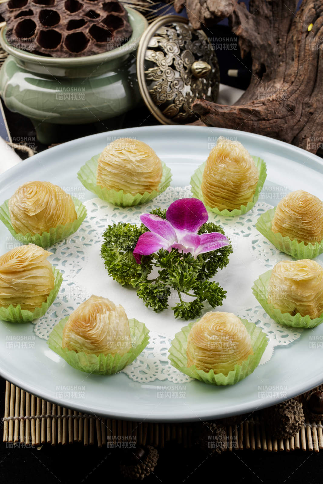 青瓷盘装的木瓜酥摆放在寿司帘上