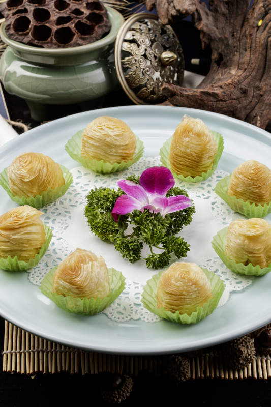 青瓷盘装的木瓜酥摆放在寿司帘上