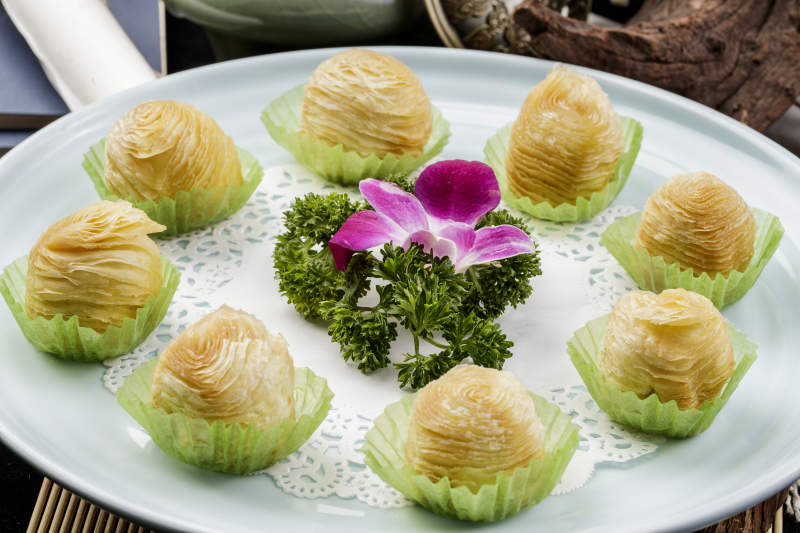 青瓷盘装的木瓜酥摆放在寿司帘上