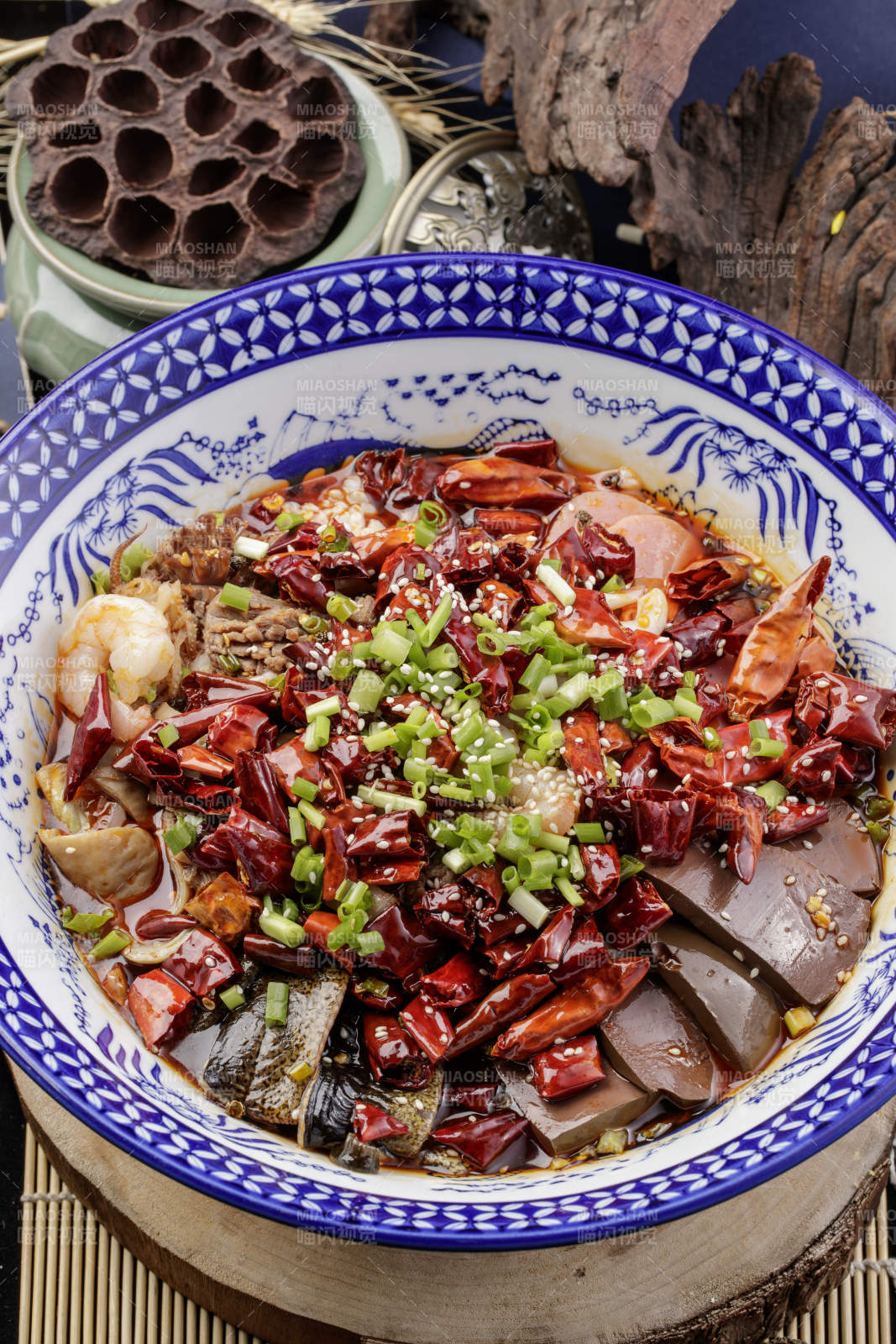 青花瓷盆裝的海鮮毛血旺擺放在樟木砧板上