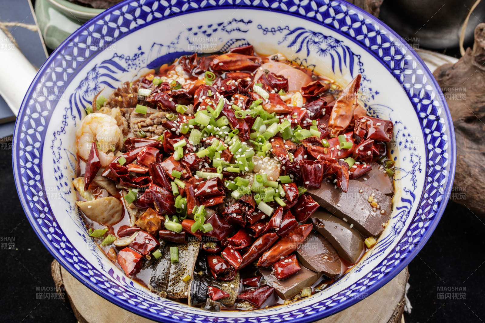 青花瓷盆裝的海鮮毛血旺擺放在樟木砧板上