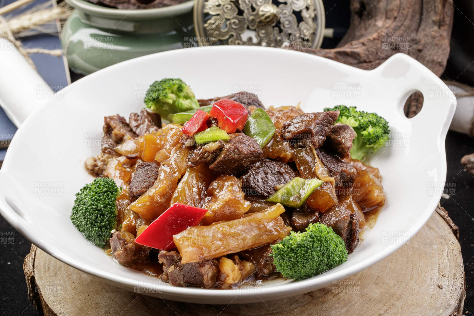 白色耳盘装的牛五花烧蹄筋摆放在樟木砧板上