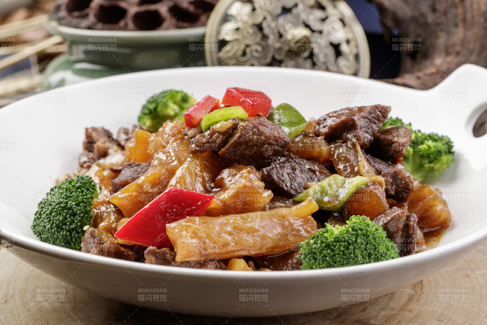 白色耳盘装的牛五花烧蹄筋摆放在樟木砧板上