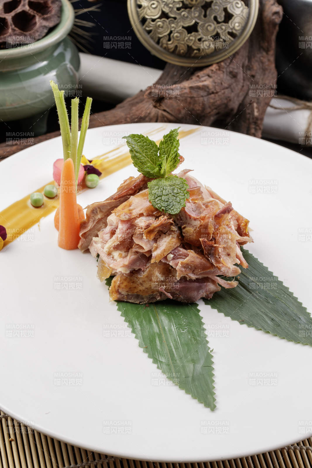 圆形白瓷盘装的风味手撕鸡摆放在寿司帘上