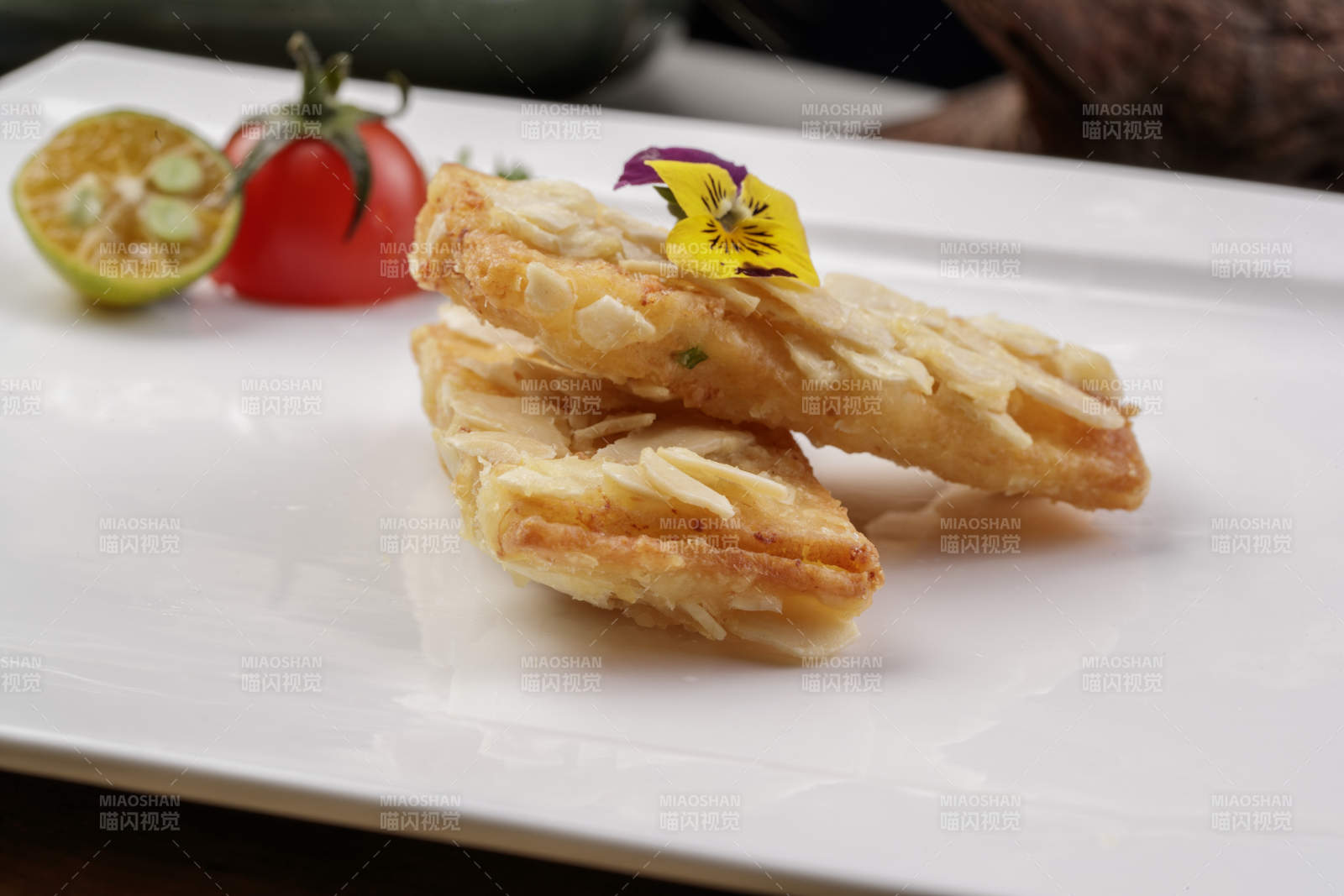 制作精良的北派鱼泥杏仁酥摆放在樟木砧板上-摄影图