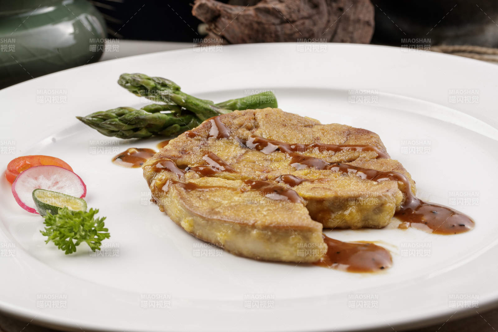 白色圆形瓷盘装的香煎法式鹅肝摆放在樟木砧板上