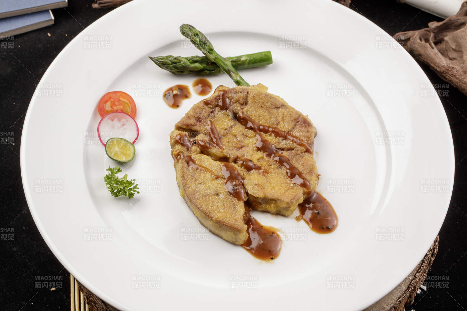 白色圆形瓷盘装的香煎法式鹅肝摆放在樟木砧板上