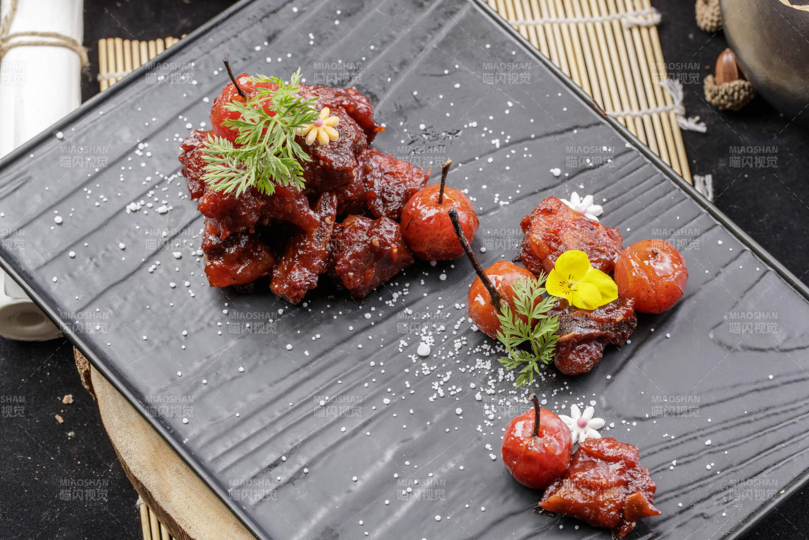 黑色石板裝的山楂牛肉擺放在壽司簾上