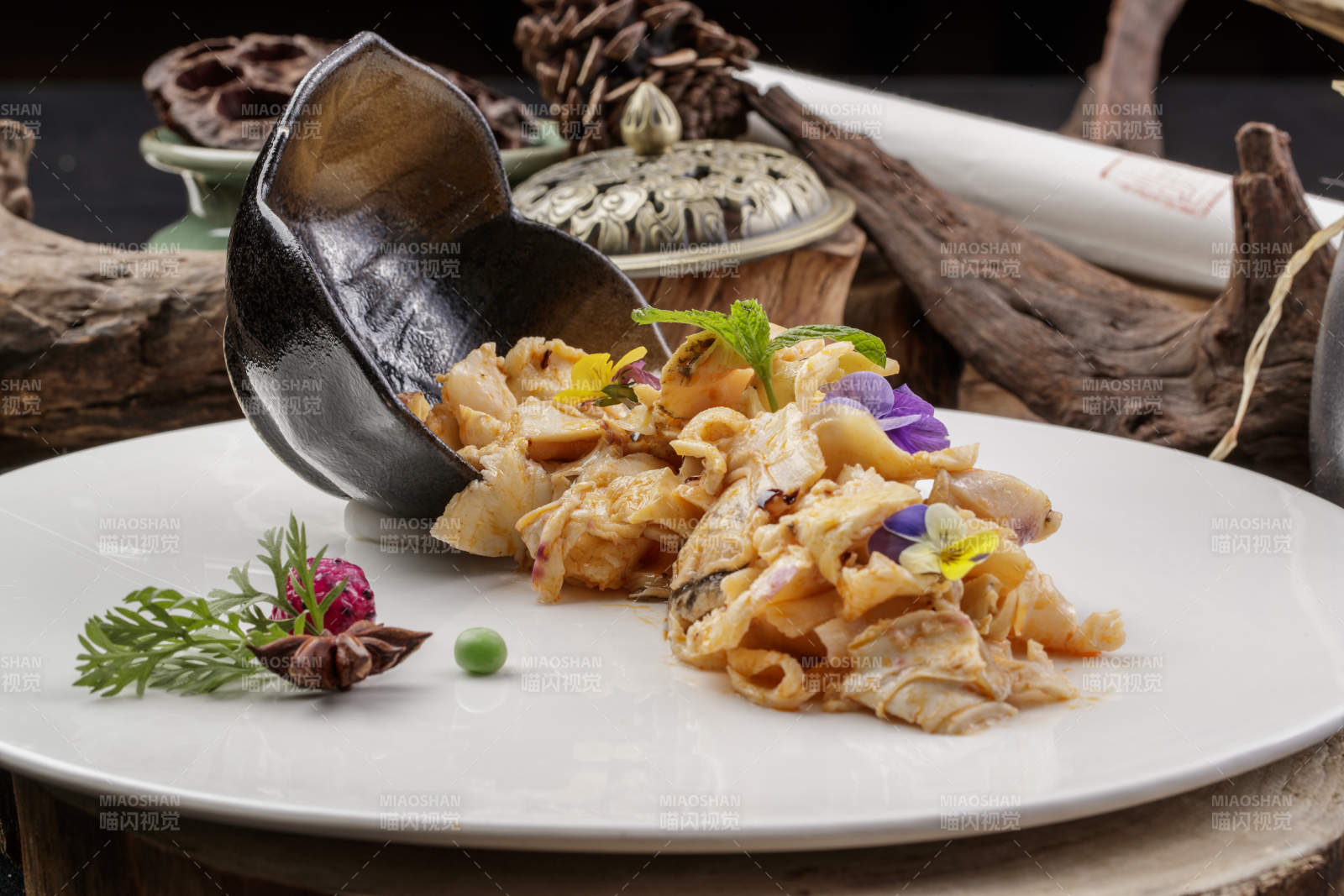 圓形瓷盤裝的溫拌海螺片擺放在壽司簾上