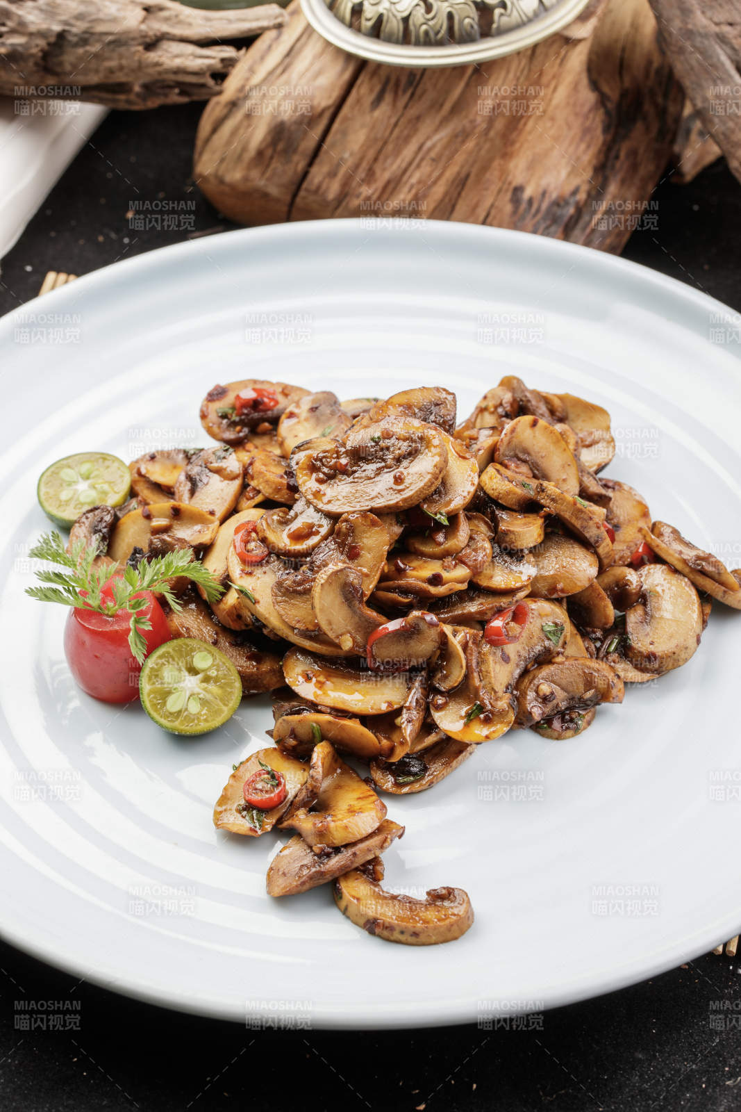 青瓷盘装的川味酱爆鲜口蘑摆放在寿司帘上