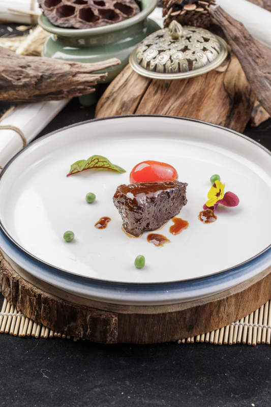 圆形瓷盘装的一品雪花和牛摆放在寿司帘上