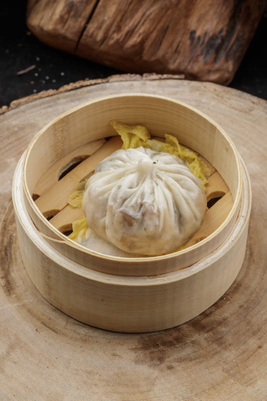 薄皮馅大的酱肉大汤包摆放在樟木砧板上