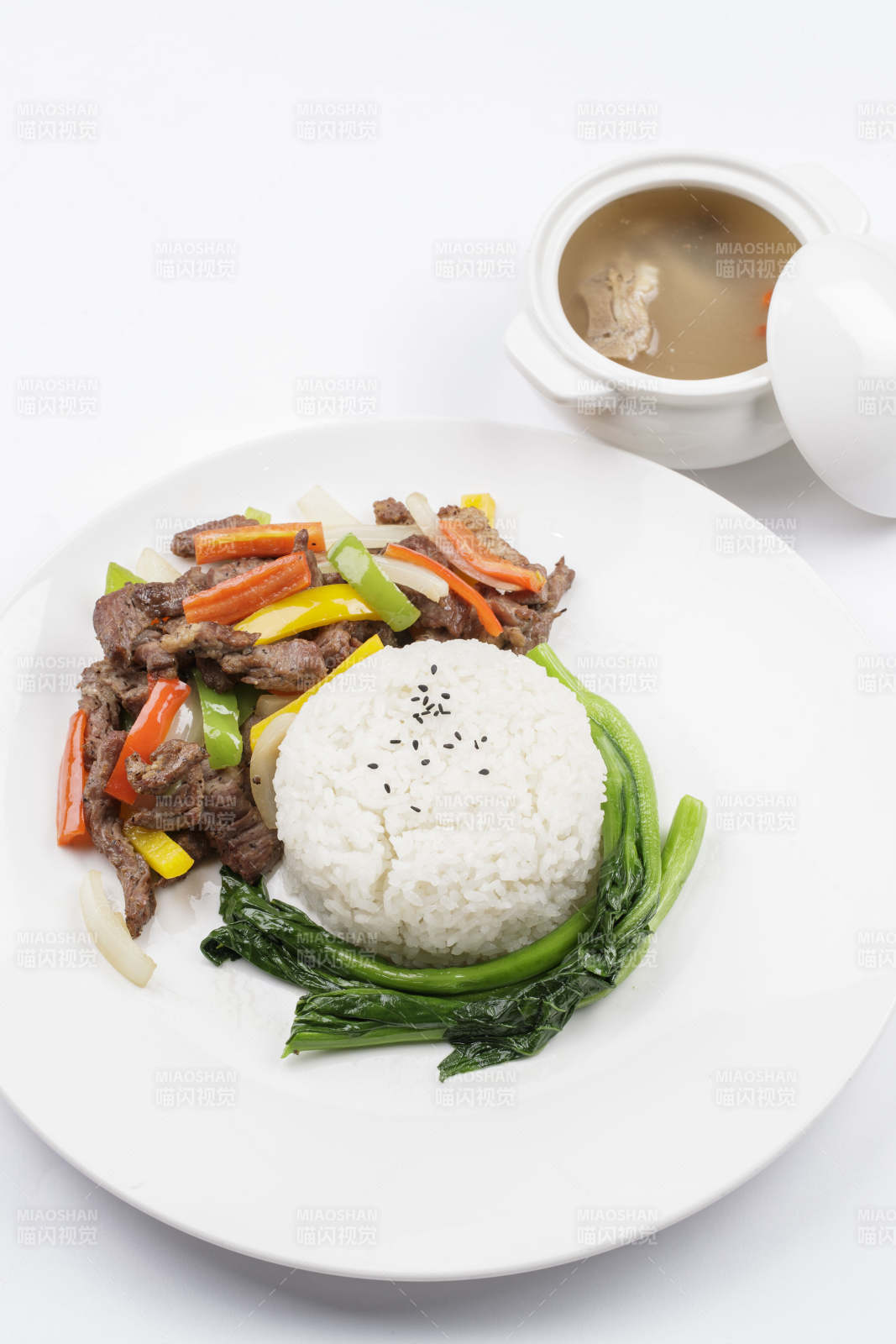 白色瓷盤裝的杭椒彩椒牛柳蓋飯