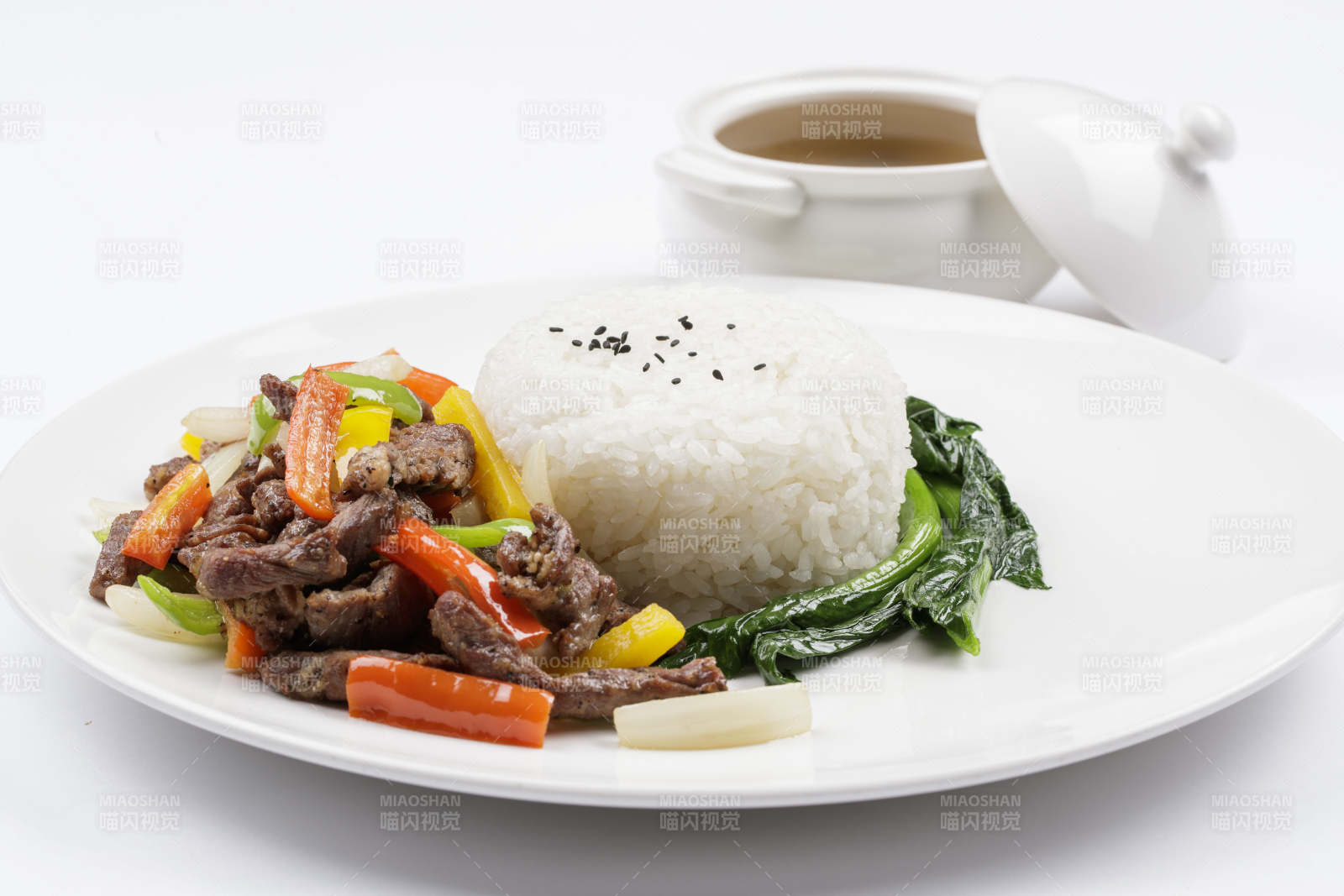 白色瓷盤裝的杭椒彩椒牛柳蓋飯