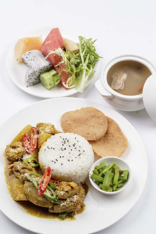 白色瓷盘装的美味咖喱鸡块盖饭