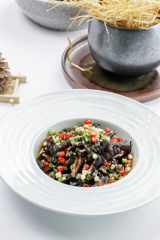 白色瓷盘装的米椒蒜香乌鸡脚