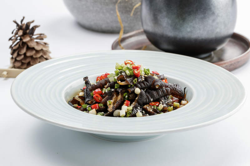 白色瓷盘装的米椒蒜香乌鸡脚