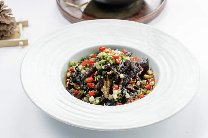 白色瓷盘装的米椒蒜香乌鸡脚