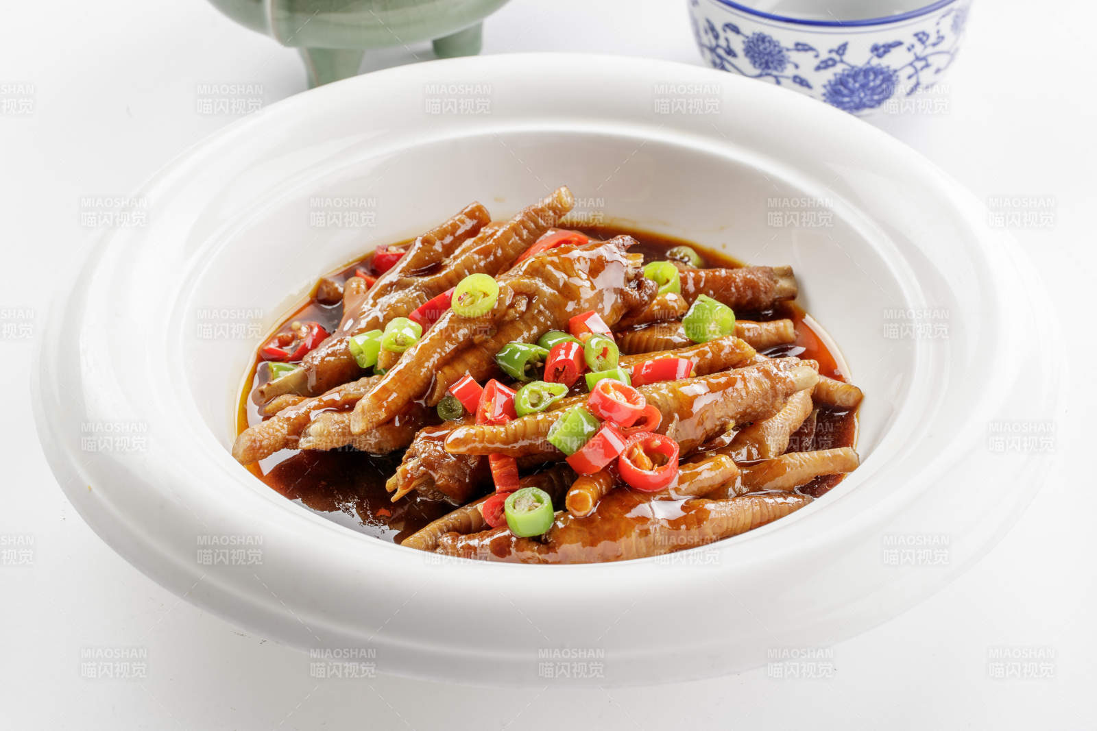 白色瓷盘装的米椒卤味凤爪-摄影图