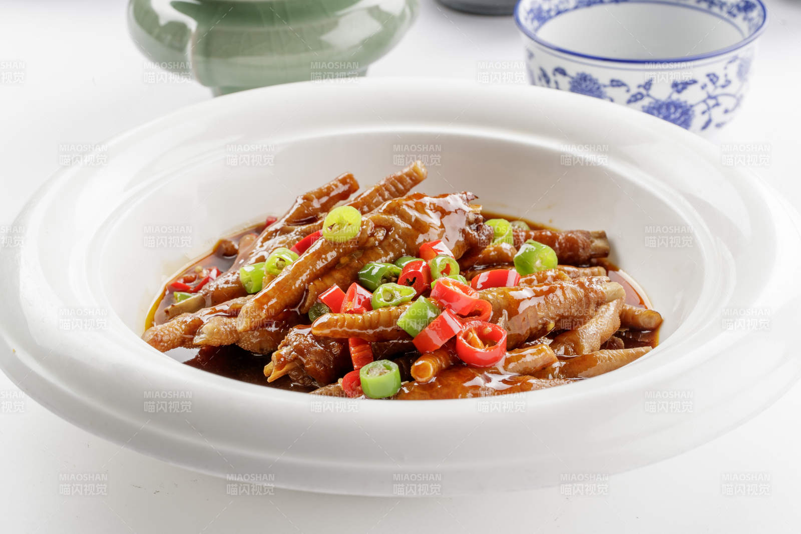 白色瓷盘装的米椒卤味凤爪-摄影图